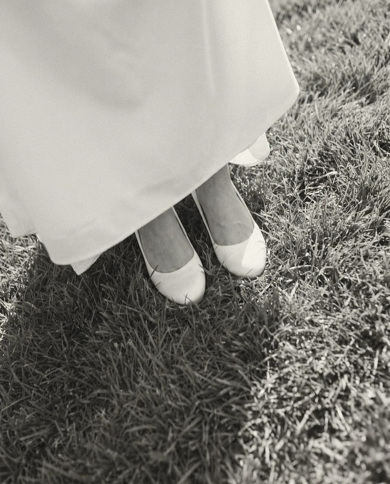 Unos zapatos de novia de satín tirados bajo una silla al final de la noche